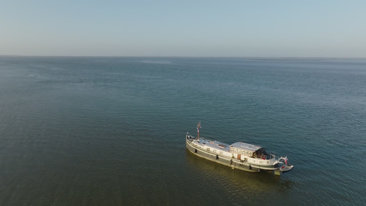 Wide view of a luxemotor boat on the edge of a channel with extensive sandbars and mudflats at Wadden sea