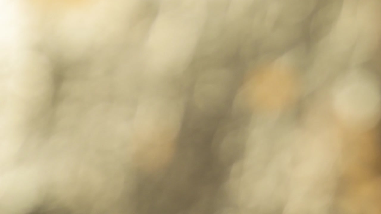 Textura de fondo bokeh de luces navideñas doradas abstractas y borrosas en 4K. Cámara lenta 4096x2160. Metraje cinematográfico a 24 fps.