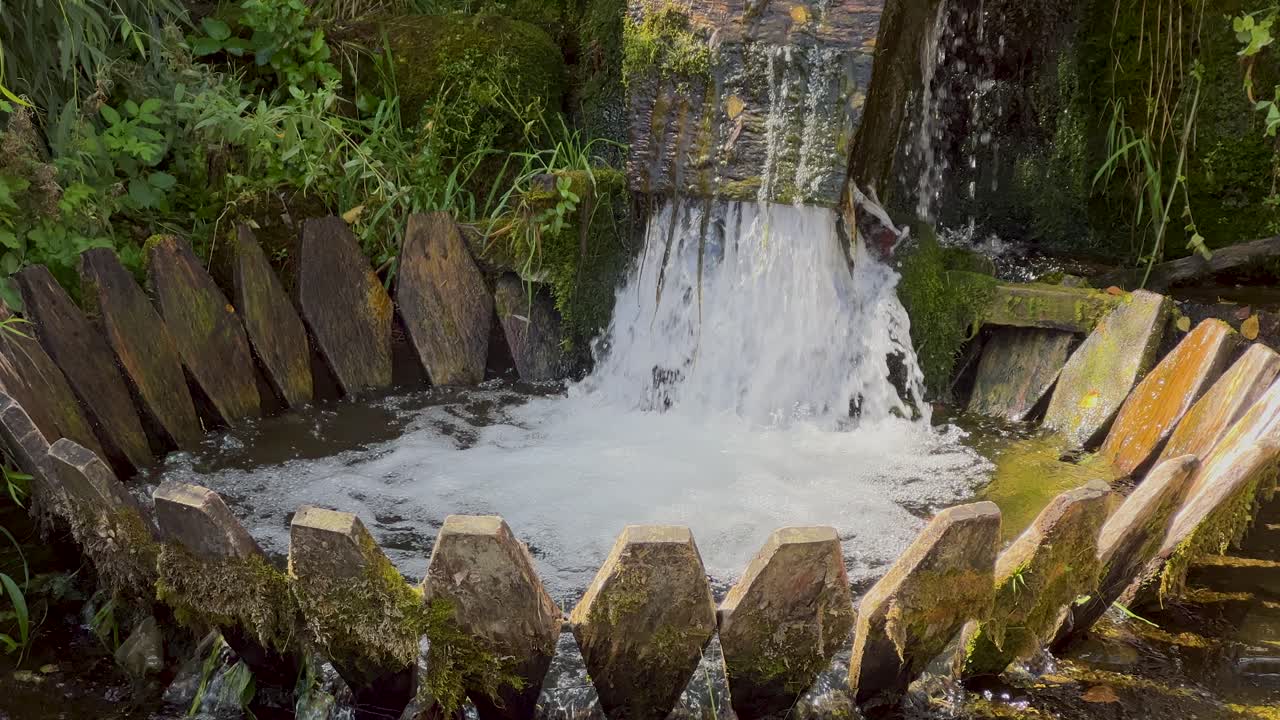Fulling wool in whirlpool. Closeup of funnel-shaped swirling whirlpool made of wooden planks for washing and fulling wool. Valyavitsa, tepavitsa in the town of Apriltsi, Bulgaria