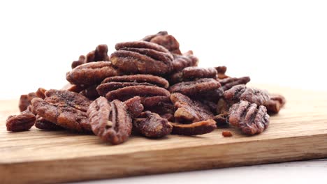 Tasty-pecan-nut-on-a-wooden-board-on-white--table-,