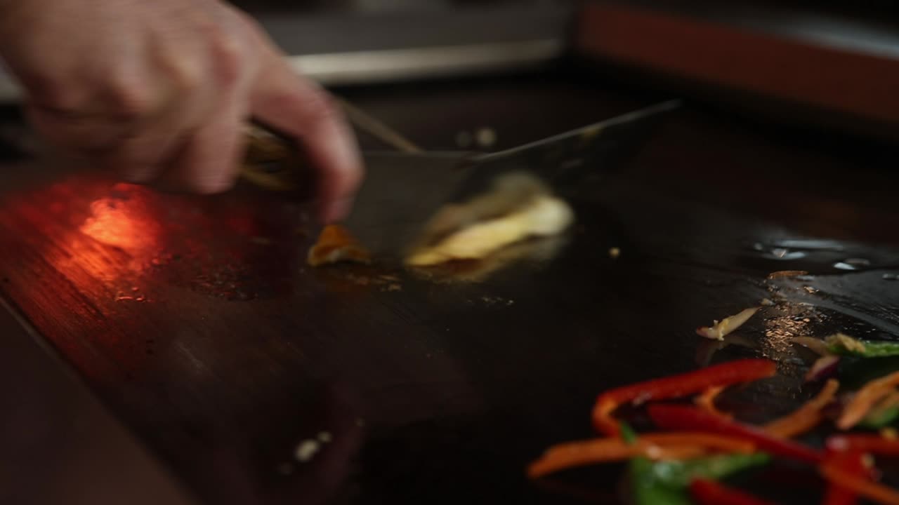Chef che cucina un'omelette con verdure su una piastra calda