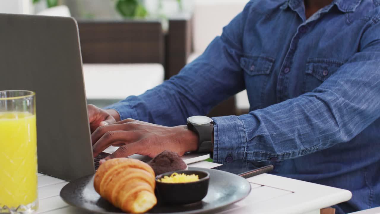 African american businessman using laptop in cafe