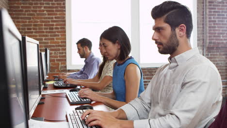 el personal usa computadoras sentado en escritorios en la oficina filmado en r3d