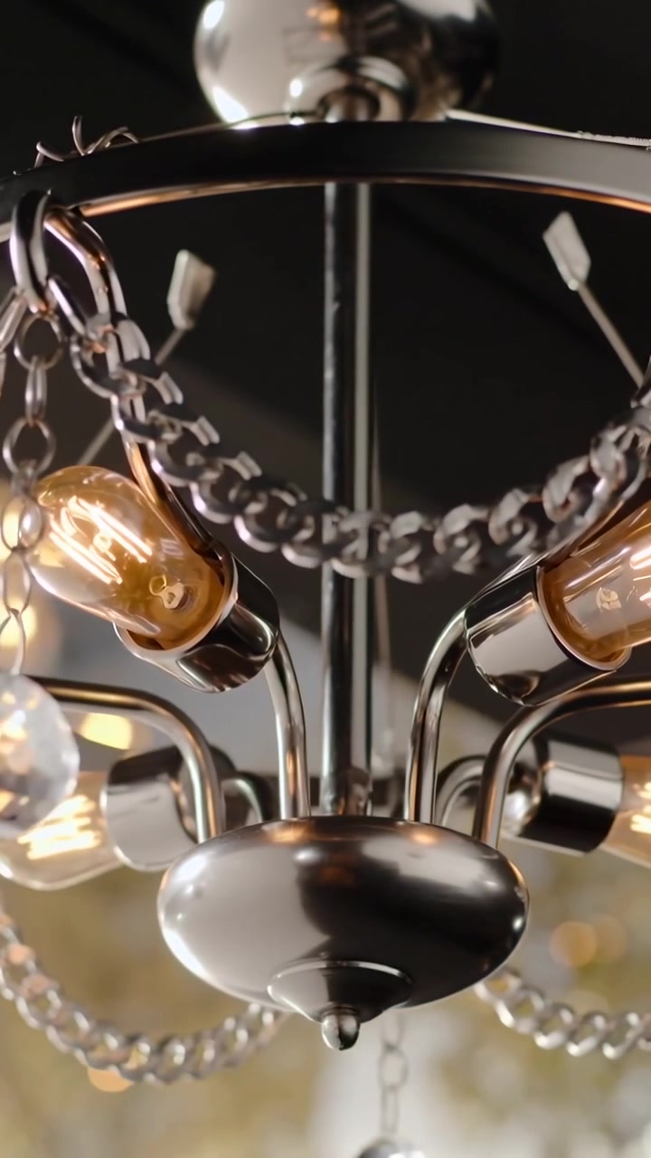 Video verticale: La telecamera si allontana rivelando un lampadario cromato sul soffitto, mostrando lampadine e cristalli.