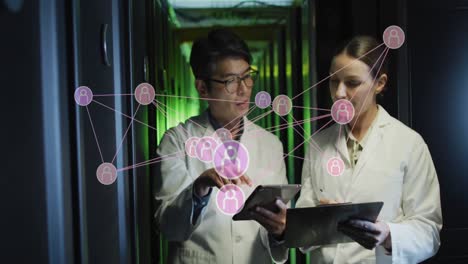 animation of network of profiles over diverse male and female engineers discussing at server room