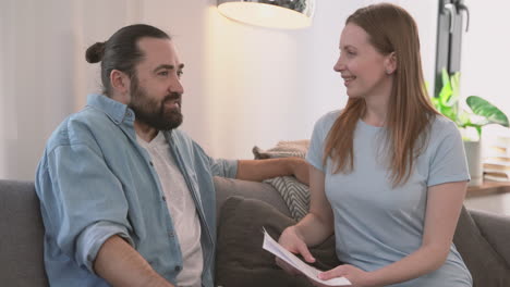 Bearded-Man-And-Beautiful-Woman-Have-A-Relaxed-Conversation-Sitting-On-The-Sofa-1