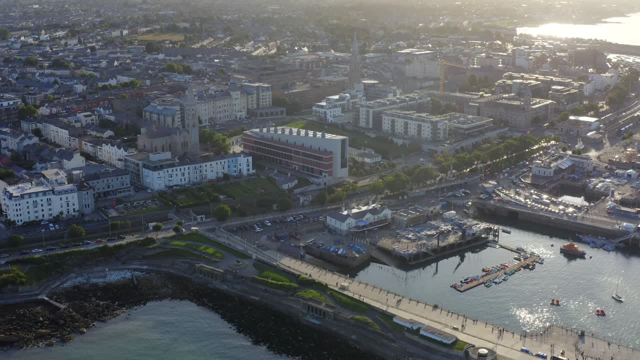 Lexicon, Dún Laoghaire, Dublin, Ireland, August 2021. Drone slowly orbits modern library building surrounded by coastal town