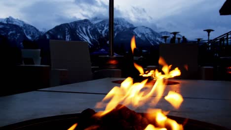 Close-up-of-campfire-against-snowy-mountain