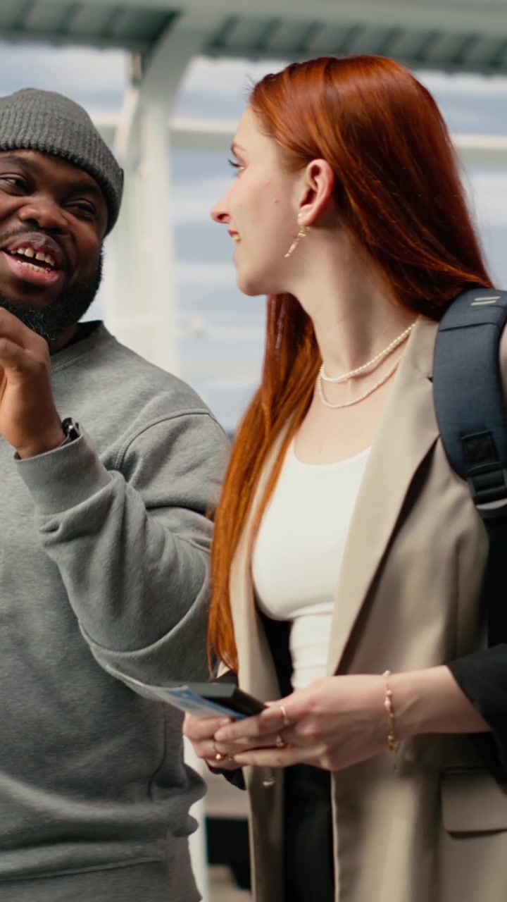 Vertical video Friends walking and talking in airport, managing vacation trip details