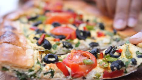 close up of turkish pide with cheese, tomatoes, olives and green peppers