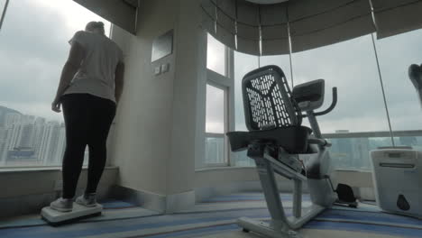 woman weighing on scales in the gym