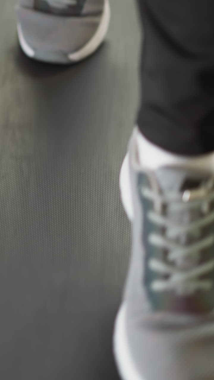 mujer se dedica a correr en una cinta de correr en casa de cerca. mujer activa en zapatos deportivos corre haciendo ejercicio en una máquina de entrenamiento en casa en cámara lenta. entrenamiento residencial