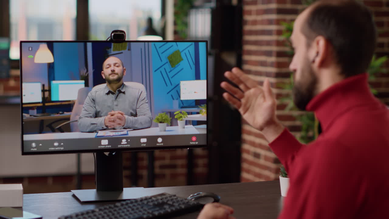 Young man attending online business videocall on computer