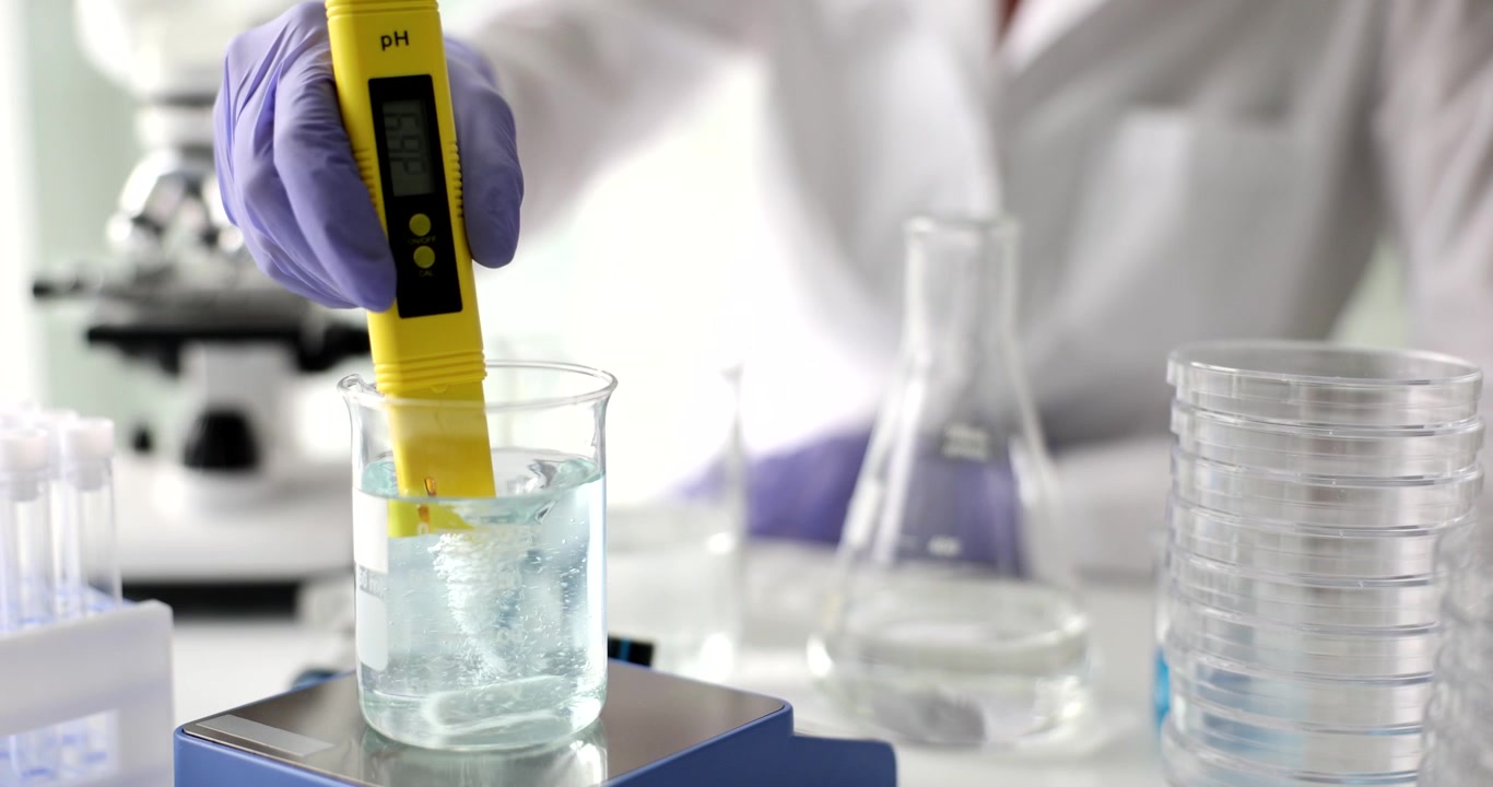 Scienziato testa l'acidità dell'acqua vorticosa con uno strumento digitale per il pH
