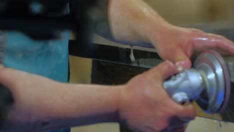 close-up-of-worker-polishing-edge-of-granite-kitchen-countertop---quartz--rock-with-a-polisher-with-water-in-a-warehouse