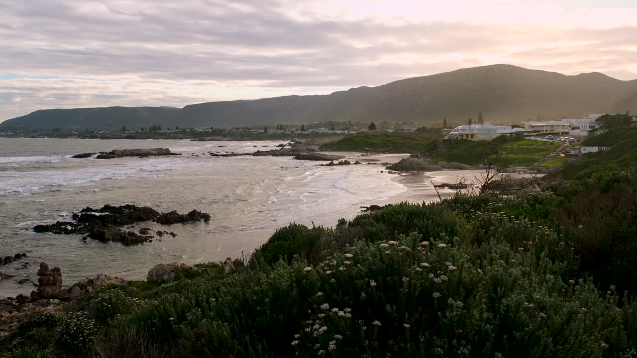 Sunset view over coastal fynbos of scenic Voëlklip beach and Hermanus coastline