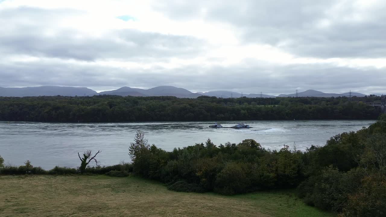 Aerial view establishing misty Snowdonia mountains and Britannia bridge over the Menai Straits