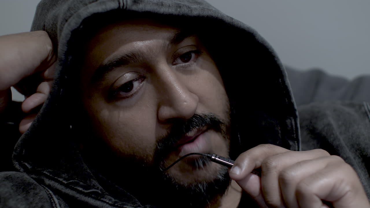 captura de pantalla de un joven asiático confiado que usa capucha y hace una llamada de conferencia con auriculares