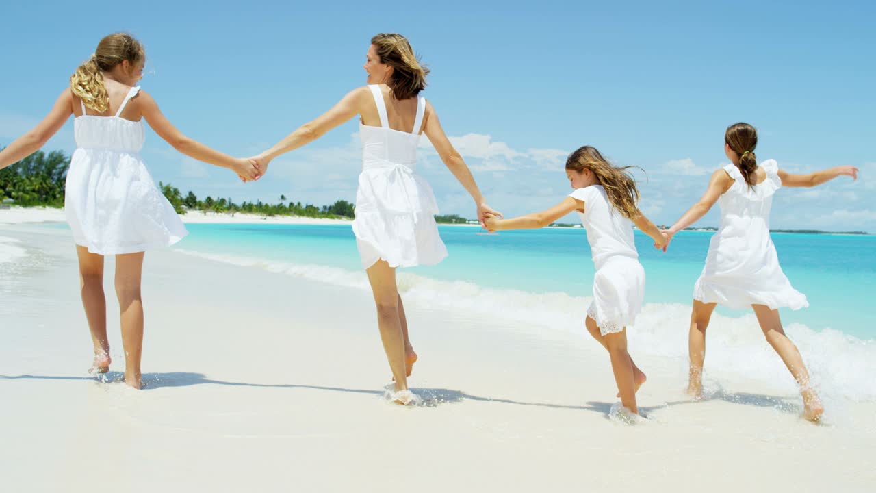 백인 어머니 와 딸 들 이 열대 해변 에서 산책 하고 있다