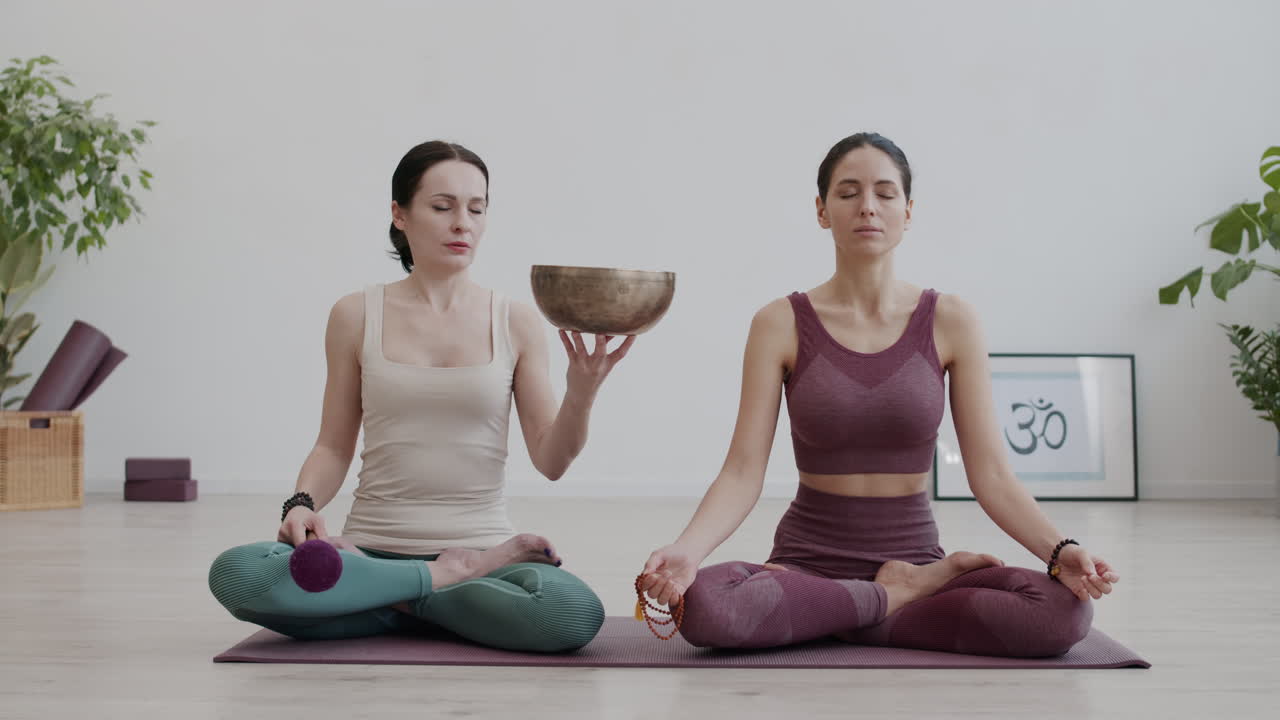 dos mujeres meditando con un cuenco de canto tradicional