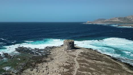 sea current and waves crashing at la pelosa tower sardinia, aerial