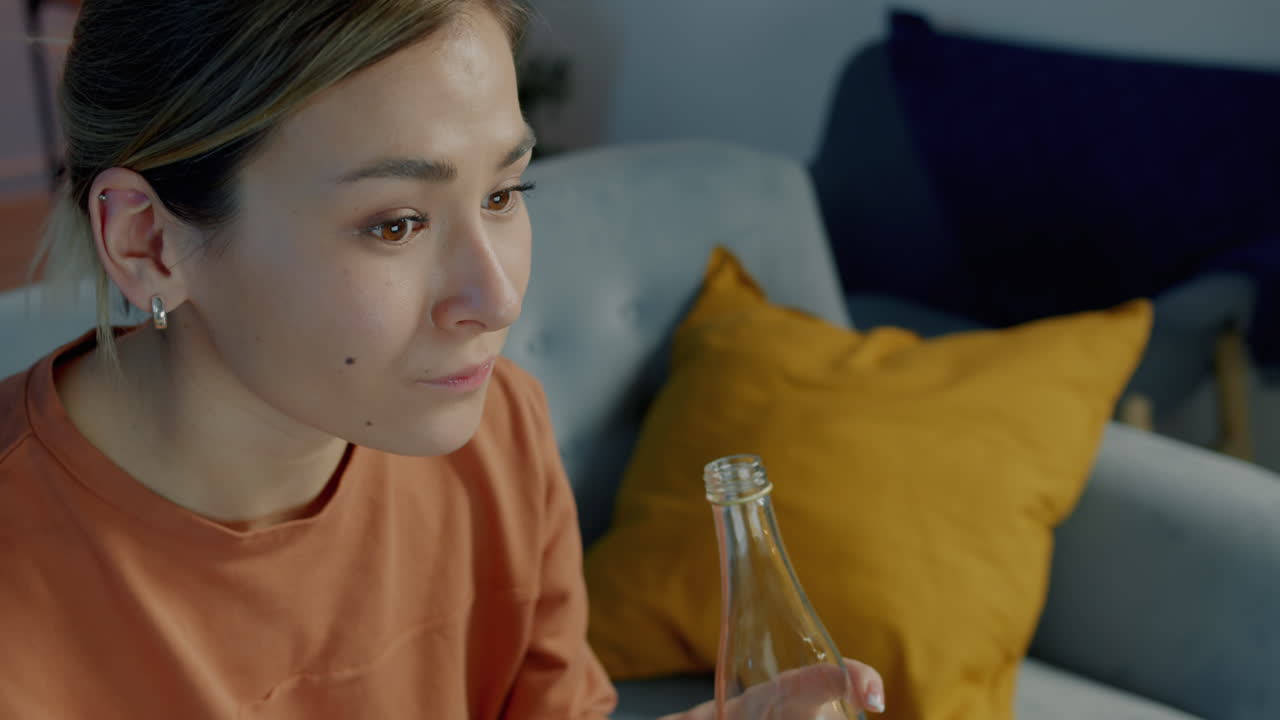 Woman drinking a beverage on a couch at home