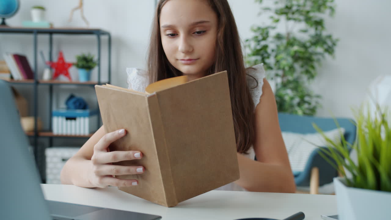 Una chica leyendo un libro en casa.