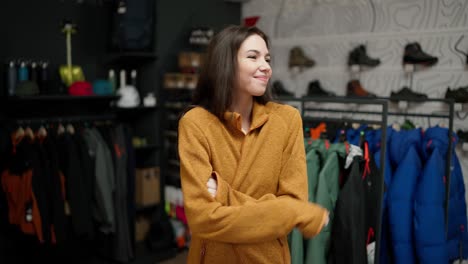 Woman-chooses-jacket-in-a-store-shopping-mall-and-posing