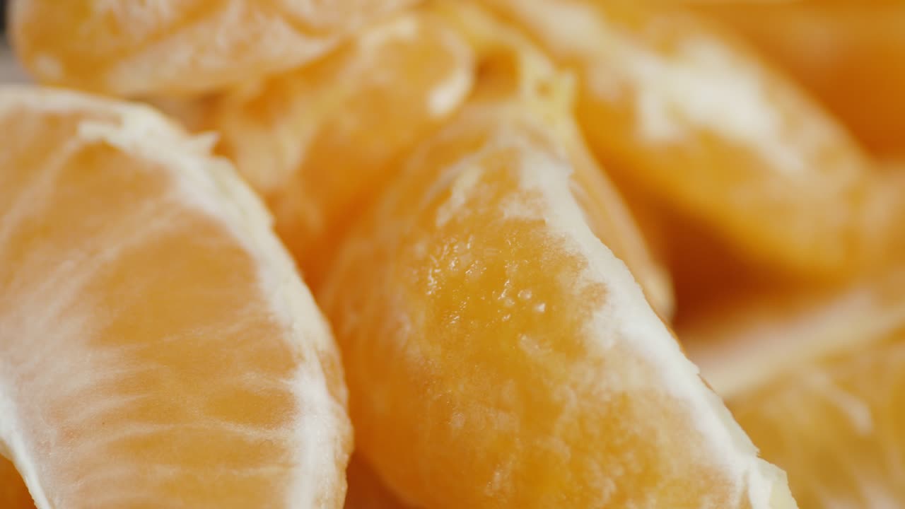 las piezas de mandarinas maduras giran lentamente.