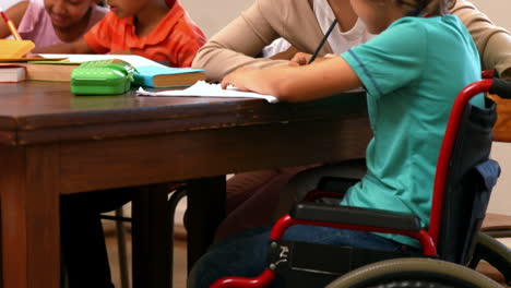 maestra ayudando a un niño pequeño durante la clase