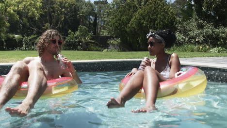 diverse couple, a caucasian man and an african american woman, enjoy pool time