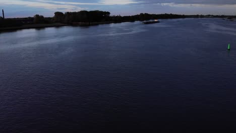 Tranquilidad-De-Un-Río-Con-Petrolero-Navegando-Al-Atardecer-Cerca-De-Barendrecht,-Países-Bajos