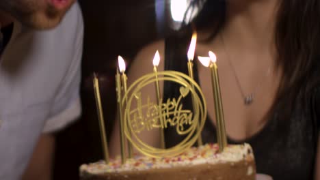 hombre cu sopla las velas del pastel de cumpleaños