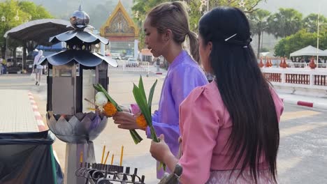 women praying at a thai temple