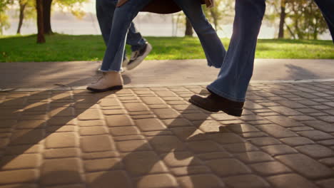 Legs-walking-paving-street-close-up.-Family-enjoying-warn-sunny-evening-in-park.