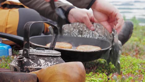 people cooking meat patties in the meadow of norway