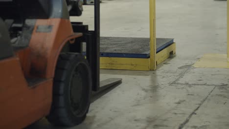 forklift parked in front of industrial scale, waiting to do warehouse work