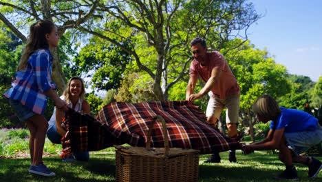 Family-spreading-the-picnic-blanket-4k