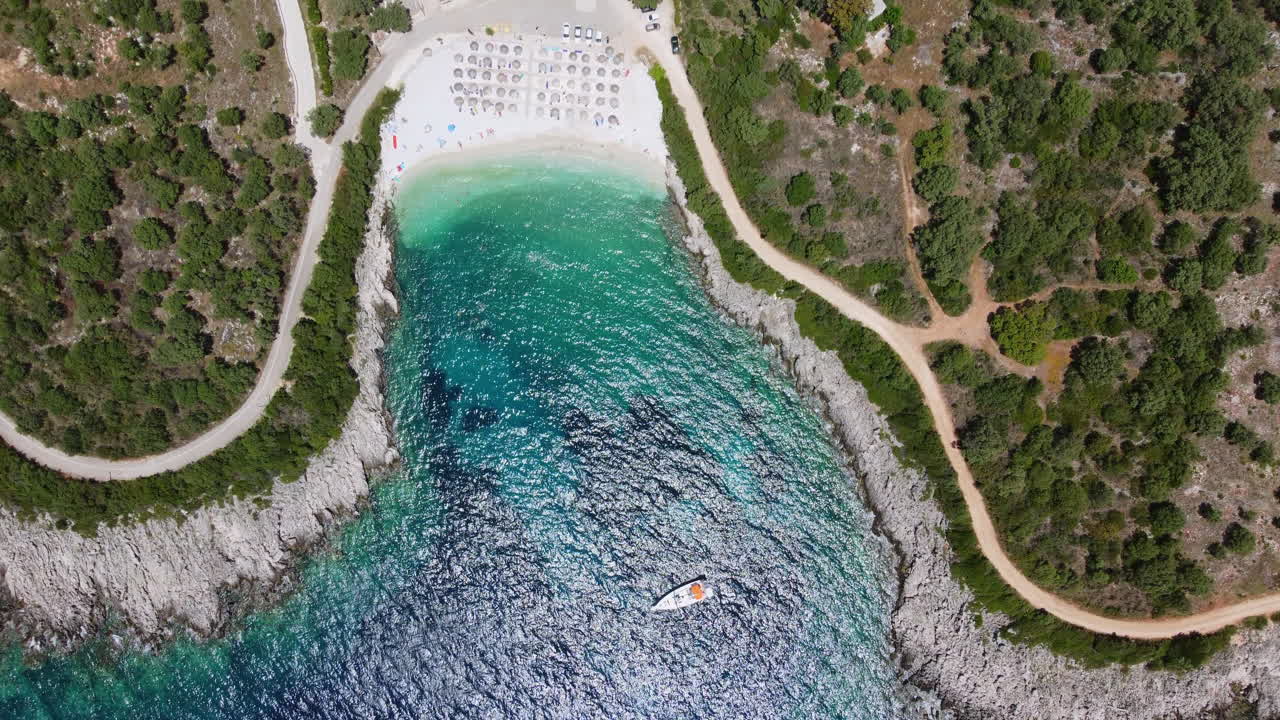 Top down drone shot of Ammousa Beach with a sailing boat