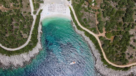 top down drone shot of ammousa beach with a sailing boat