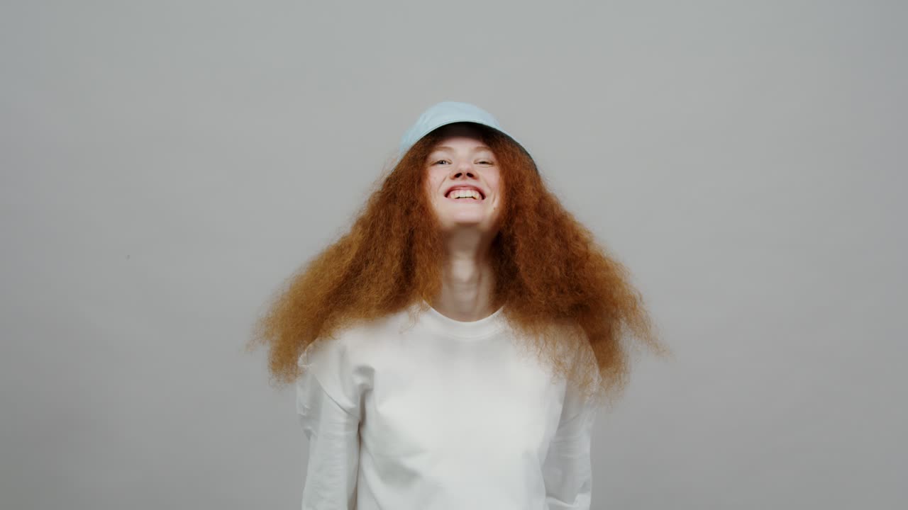 곱슬 빨간 머리카락과 버 모자를 가진 여자