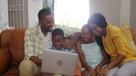 Familia-Usando-Una-Computadora-Portátil-En-La-Sala-De-Estar-4k