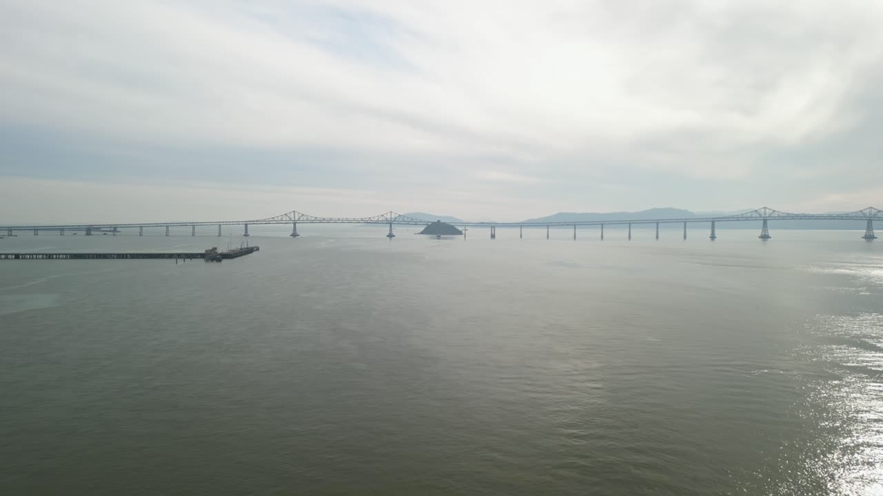 A drone shot of the Richmond–San Rafael Bridge arching over the waters by Point Molate.