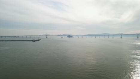a drone shot of the richmond–san rafael bridge arching over the waters by point molate.