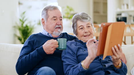 Senior-couple,-home-and-tablet-in-living-room