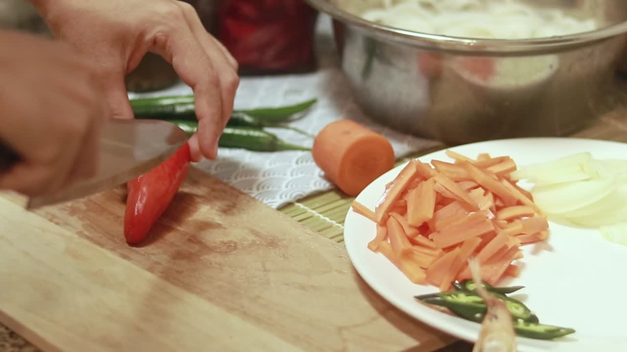 Deseeding a red paprika, candid kitchen scene of a person preparing ingredients for cooking at home