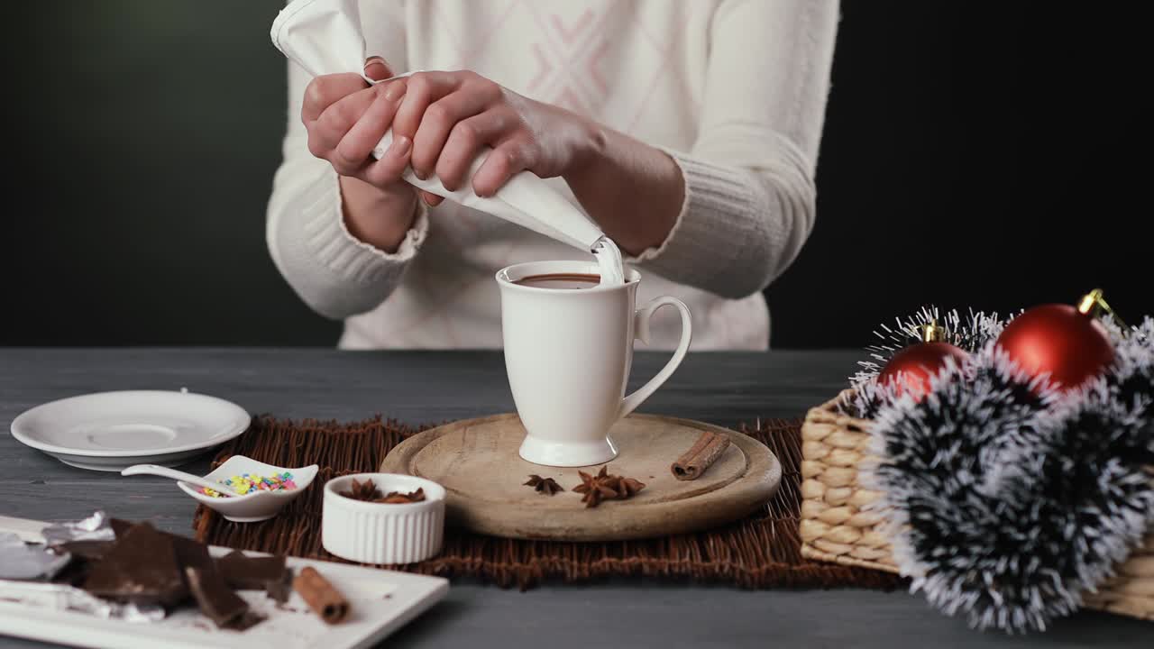 una mujer decorando chocolate caliente con crema batida.