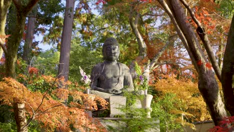 frontal cinematic shot over buddha statue flanked by beautiful autumn colors