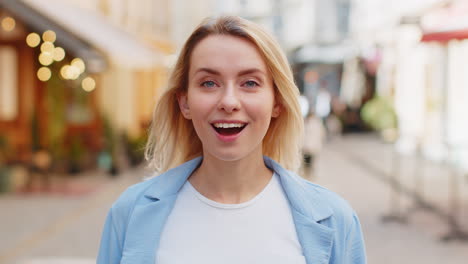 amazed woman looking surprised at camera with big open eyes, shocked by sudden victory good news