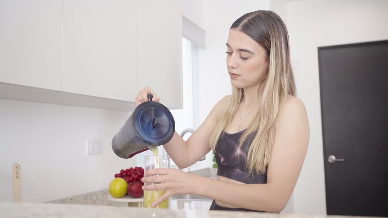 joven adolescente saludable haciendo batido de frutas nutritivas después del entrenamiento